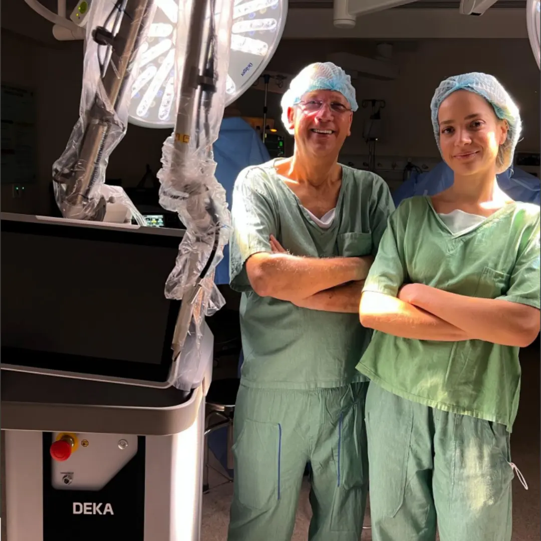 Docente e participante no centro cirúrgico ao lado do laser DEKA